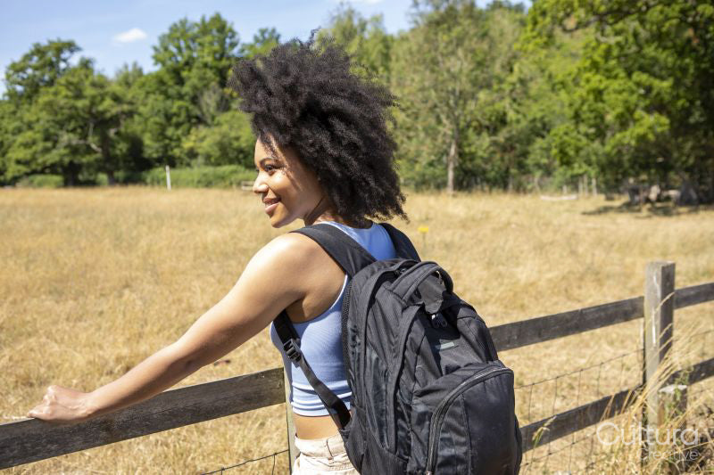 Young woman with backpack hiking in countryside