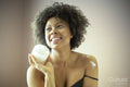 Smiling woman holding jar of moisturizer