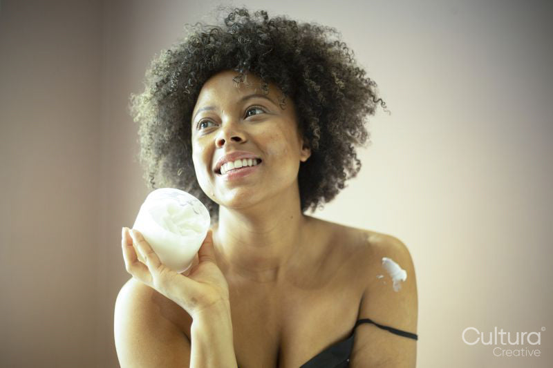 Smiling woman holding jar of moisturizer