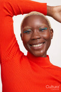 Smiling woman with short white hair, arms raised