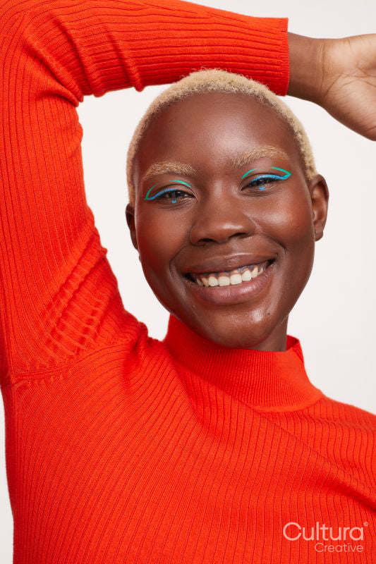 Smiling woman with short white hair, arms raised