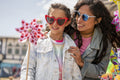 Smiling mother and daughter playing with pinwheel