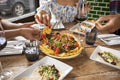 Close-up of friends enjoying Me,ican food at restaurant table