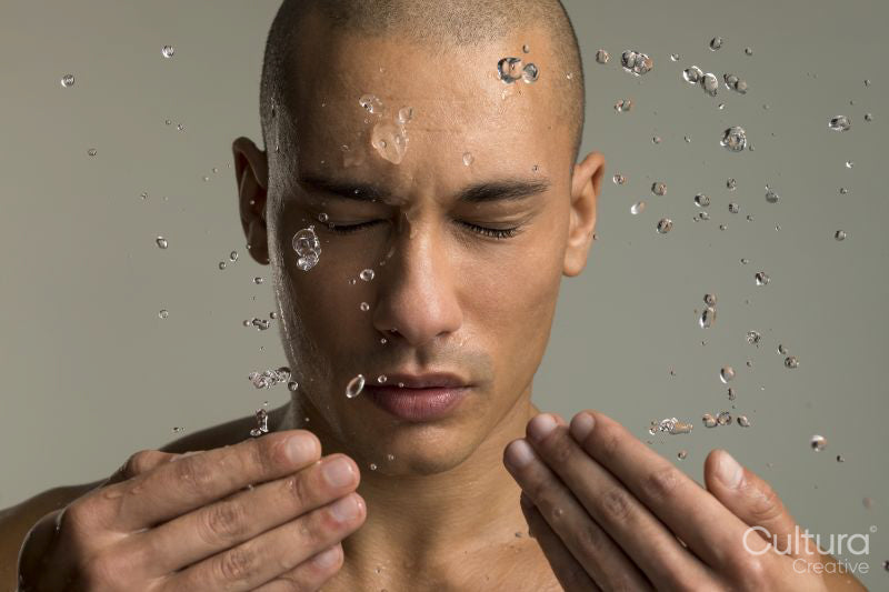 Studio portrait of man splashing water on face