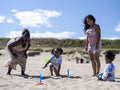 Family with children playing ring toss on beach