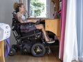 Woman in electric wheelchair working on laptop