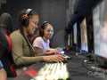 Female friends playing video games in gaming club