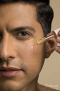 Close-up of man applying oil on face