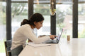 Girl doing homework and using laptop in living room