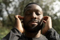 Close-up of man with earbuds standing in park