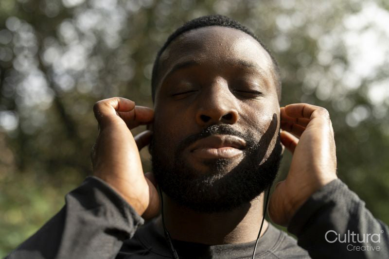 Close-up of man with earbuds standing in park