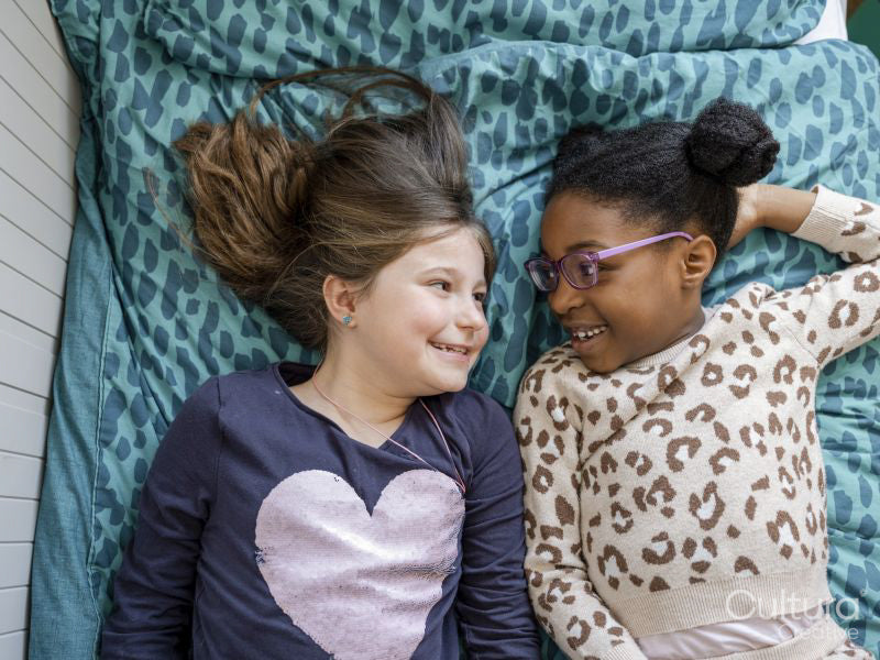 Smiling girl friends lying on bed