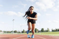 Female athlete sprinting off starting line at stadium