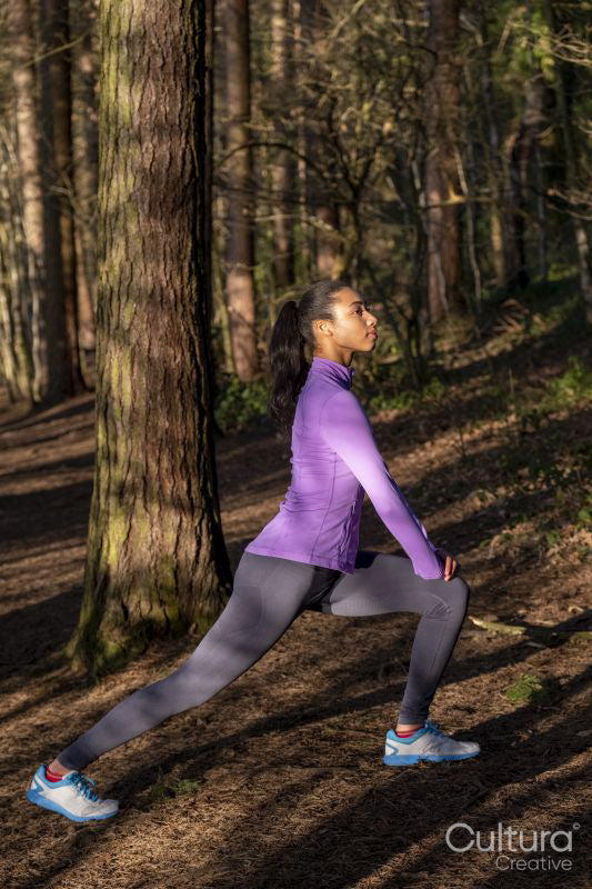 Young woman stretching in forest