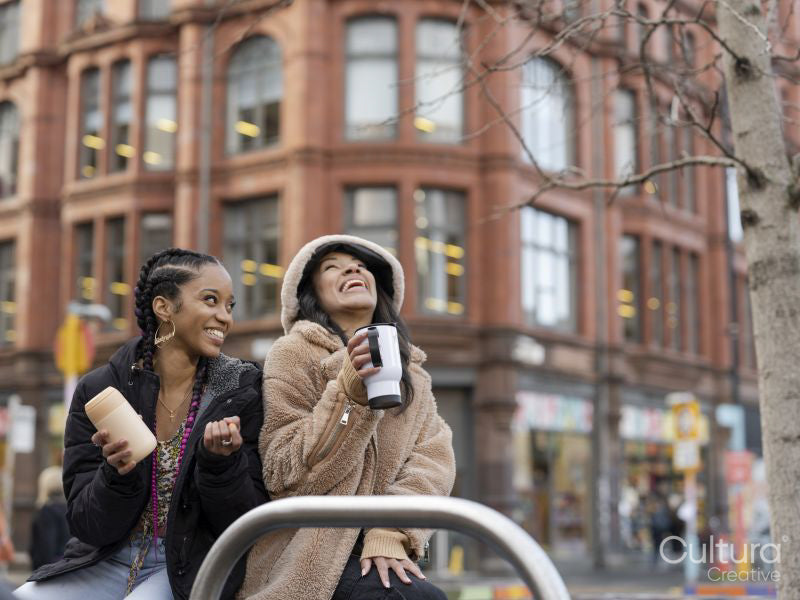 Two young women drinking coffee-to-go