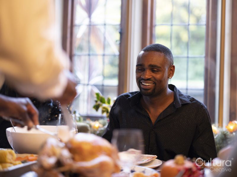 Family cutting turkey at Thanksgiving table