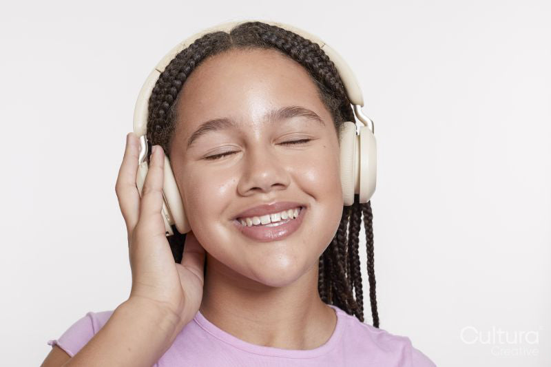 Studio portrait of smiling girl with headphones and eyes closed