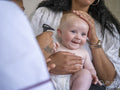 Nurse examining baby girl with otoscope