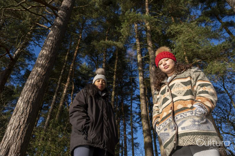 Portrait of female friends standing in forest