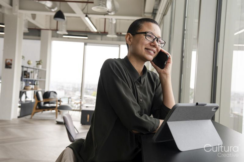 Woman using digital tablet and phone in office