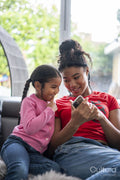 Two girls sitting on sofa looking at smartphone