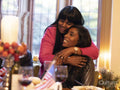 Mother hugging daughter at Thanksgiving table