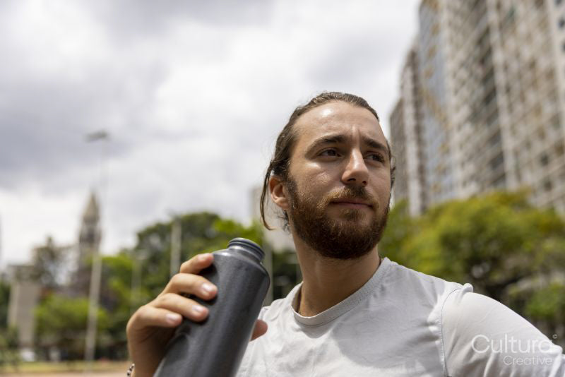 Brazil, Sao Paulo, Athletic man with bottle after workout in city