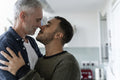 Male couple hugging and kissing at home