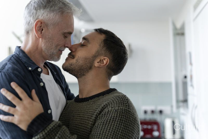 Male couple hugging and kissing at home