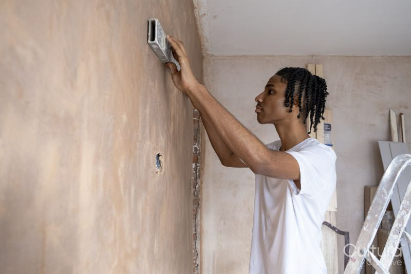Teenage boy using spirit level on wall