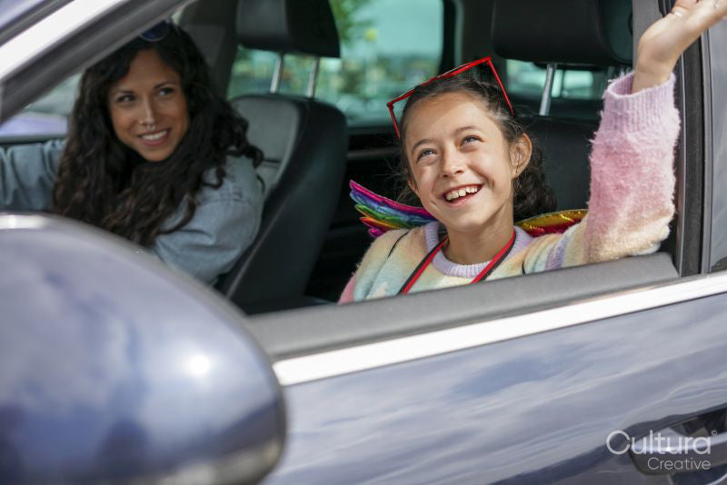 Smiling mother and daughter sitting in car