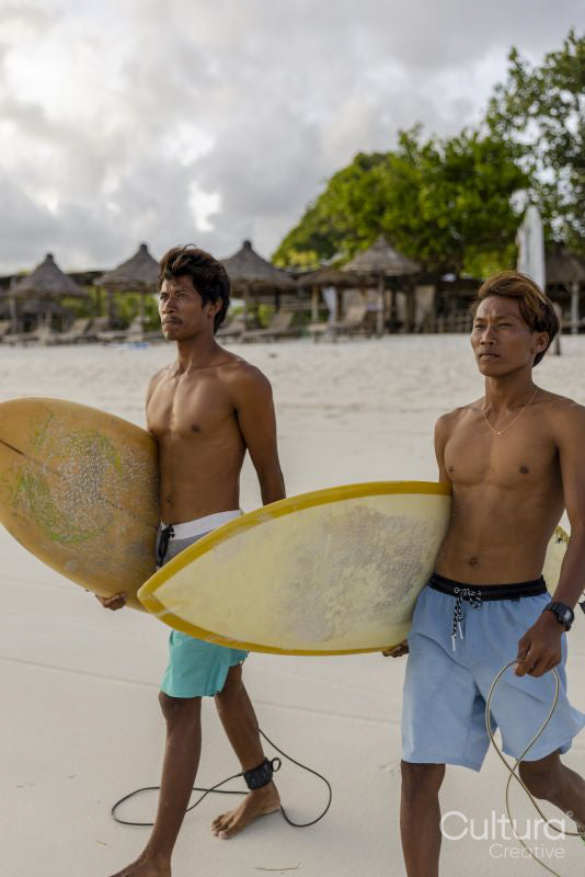 Indonesia, Lombok, Two surfers walking with surfboards on beach