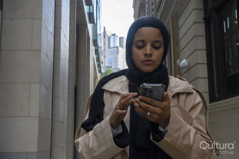 Young woman using phone in street