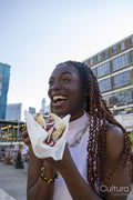 Laughing young woman eating hot dog
