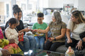 Family gathered in living room, sharing red envelopes
