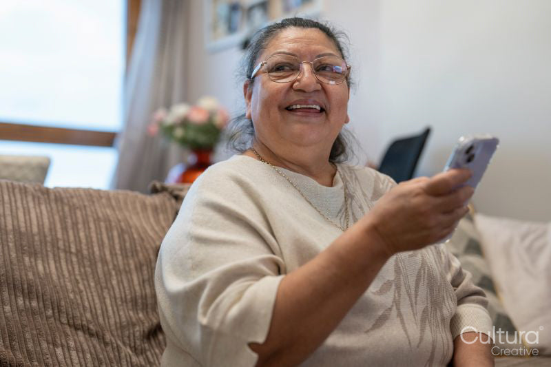 Senior woman using smart phone in living room