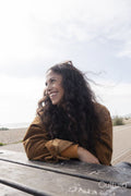 Smiling woman looking away while sitting by picnic table
