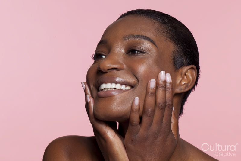 Smiling young woman touching face