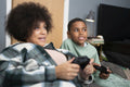Mother and son playing video games at home