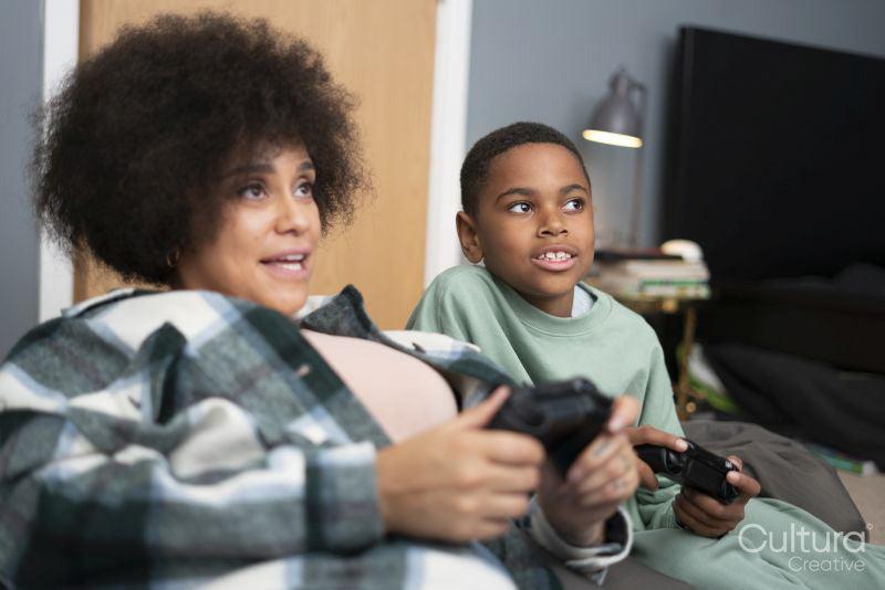 Mother and son playing video games at home