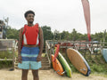 Portrait of young man standing on beach before paddleboarding