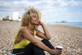 Woman drinking coffee on beach