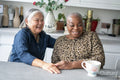 Two senior women sitting at kitchen table