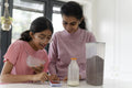 Mother and daughter using phone during breakfast