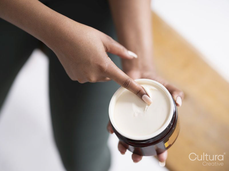 Close-up of woman holding jar with body balm