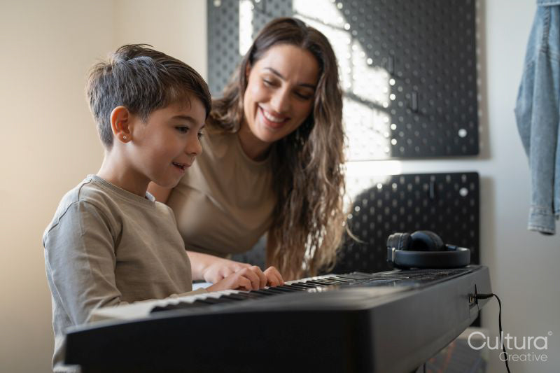 Mother and son playing music keyboard at home
