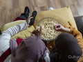 High angle view of friends sitting on sofa and eating popcorn