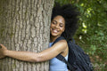 Young woman hiking in forest, hugging tree