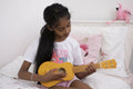 Girl playing ukulele on bed