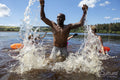 Man splashing water in lake, Yorkshire, UK